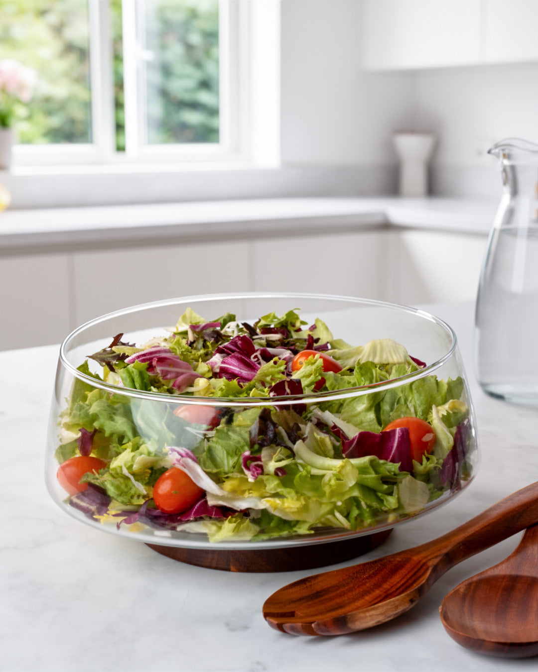 Salatschüssel aus Glas mit Salatbesteck und Untersetzer